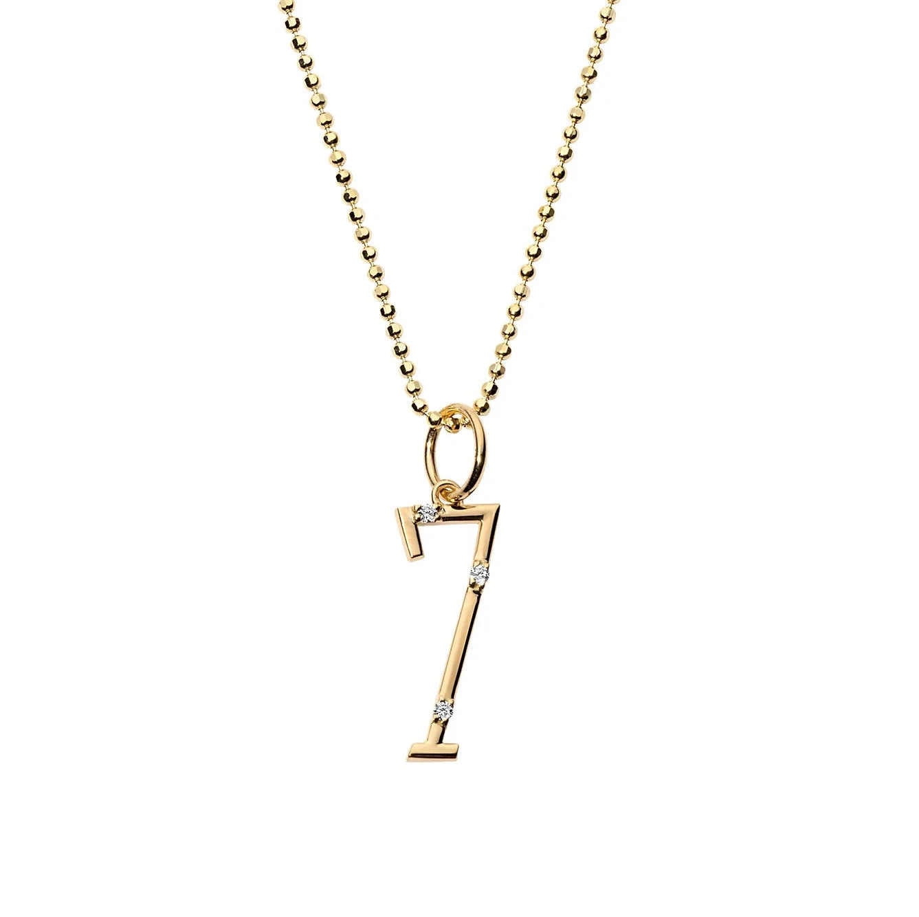 A yellow gold and diamond number 7 charm hanging from a delicate gold ball chain necklace.